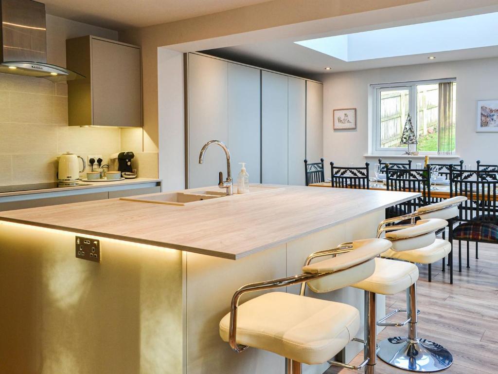 a kitchen with a large island with stools and a counter top at Cheviot in Walkington
