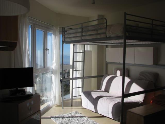 a bedroom with two bunk beds and a window at Precioso apartamento a pie de pista en Sierra Nevada in Sierra Nevada