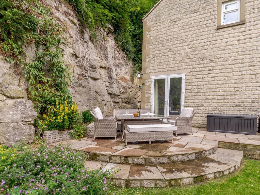 a patio with a table and chairs next to a building at Cliffside House in Matlock