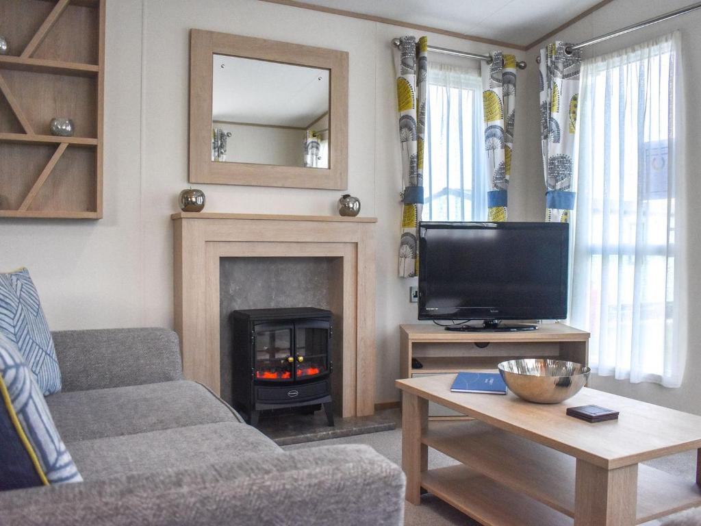 a living room with a fireplace and a tv at The Endeavour - Uk37771 in Stoupe Brow