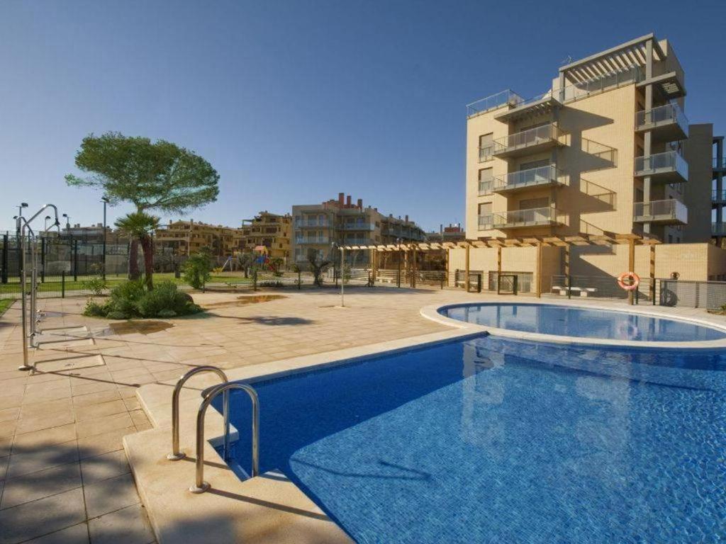 une grande piscine en face d'un bâtiment dans l'établissement Alcocebre Suites Hotel, à Alcossebre