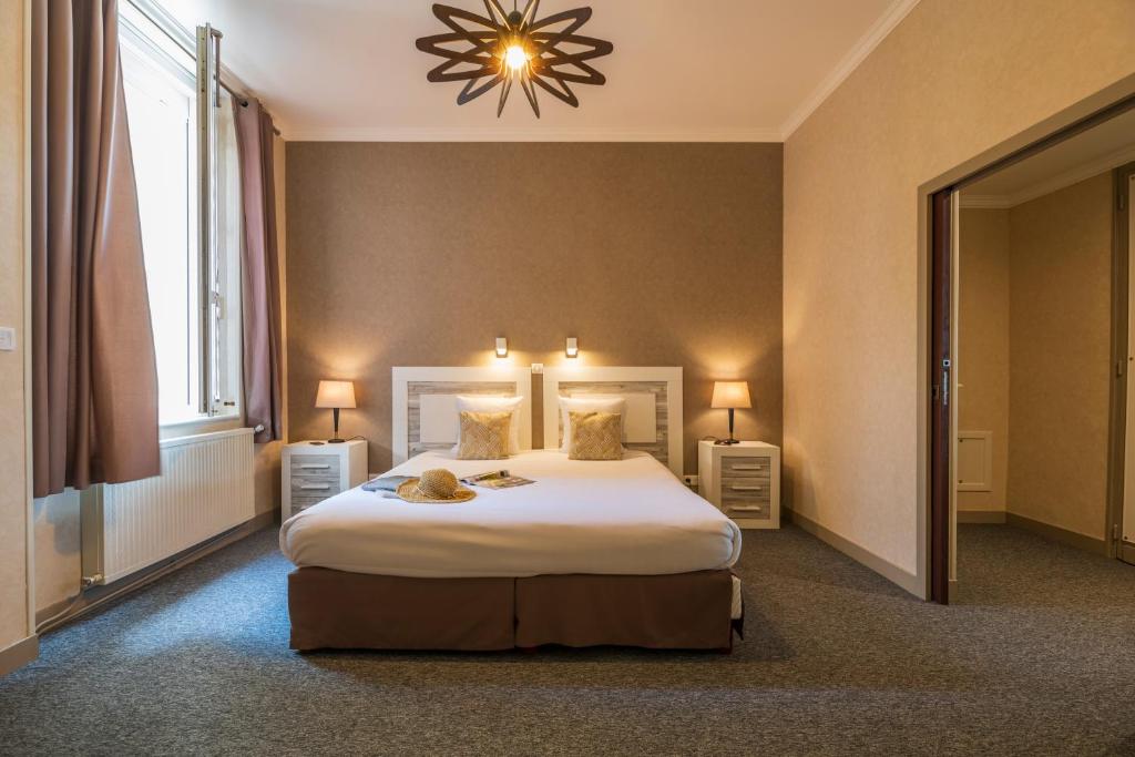 a bedroom with a large bed and a large window at CERISE Royan - Le Grand Hôtel de la Plage in Royan