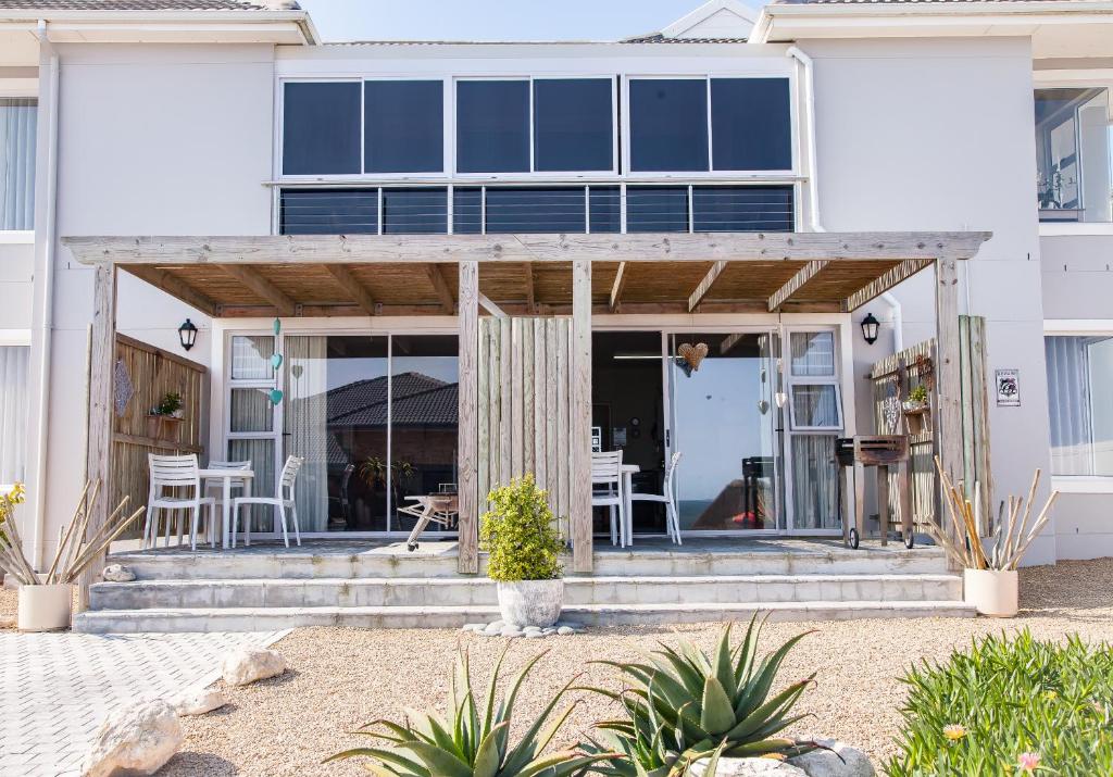 ein weißes Haus mit Glastüren und einer Terrasse in der Unterkunft 21 ON BAKOOND in Yzerfontein
