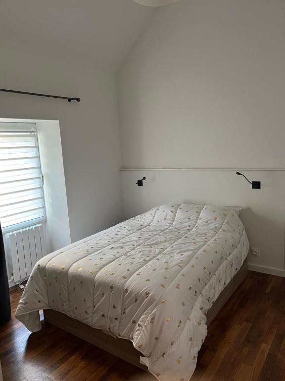 a bedroom with a bed with a white bedspread at Studio à proximité de Laval in Soulgé-sur-ouette