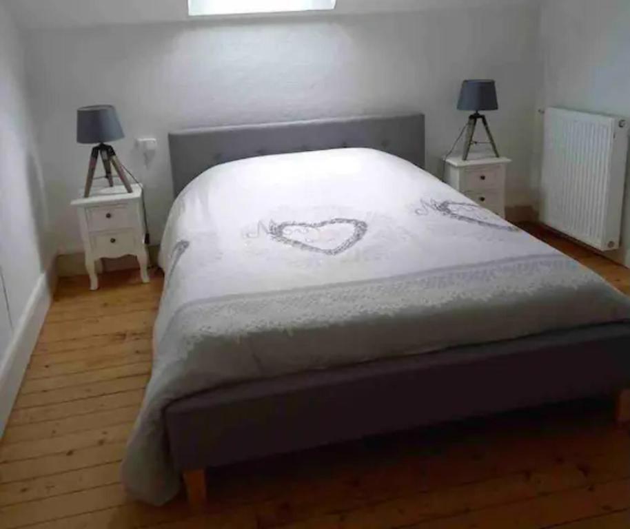ein Schlafzimmer mit einem Bett mit einem Herz darauf in der Unterkunft Appartement Hypercentre de Milly in Milly-la-Forêt