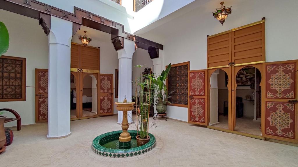 a room with a fountain in the middle of a building at RIAD DAR En-Nawat in Marrakech