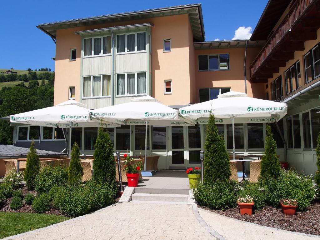a building with white umbrellas in front of it at JUFA Hotel Kaprun in Kaprun