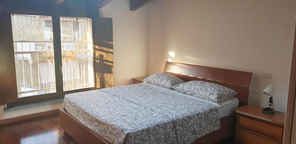 een slaapkamer met een bed en een raam bij APPARTAMENTO TORRE in Cormano