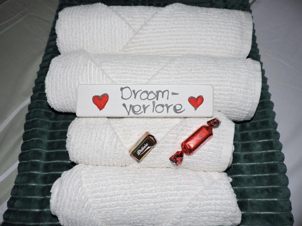 a stack of towels with a sign that reads urgent divorce at Droom Verlore in Jeffreys Bay