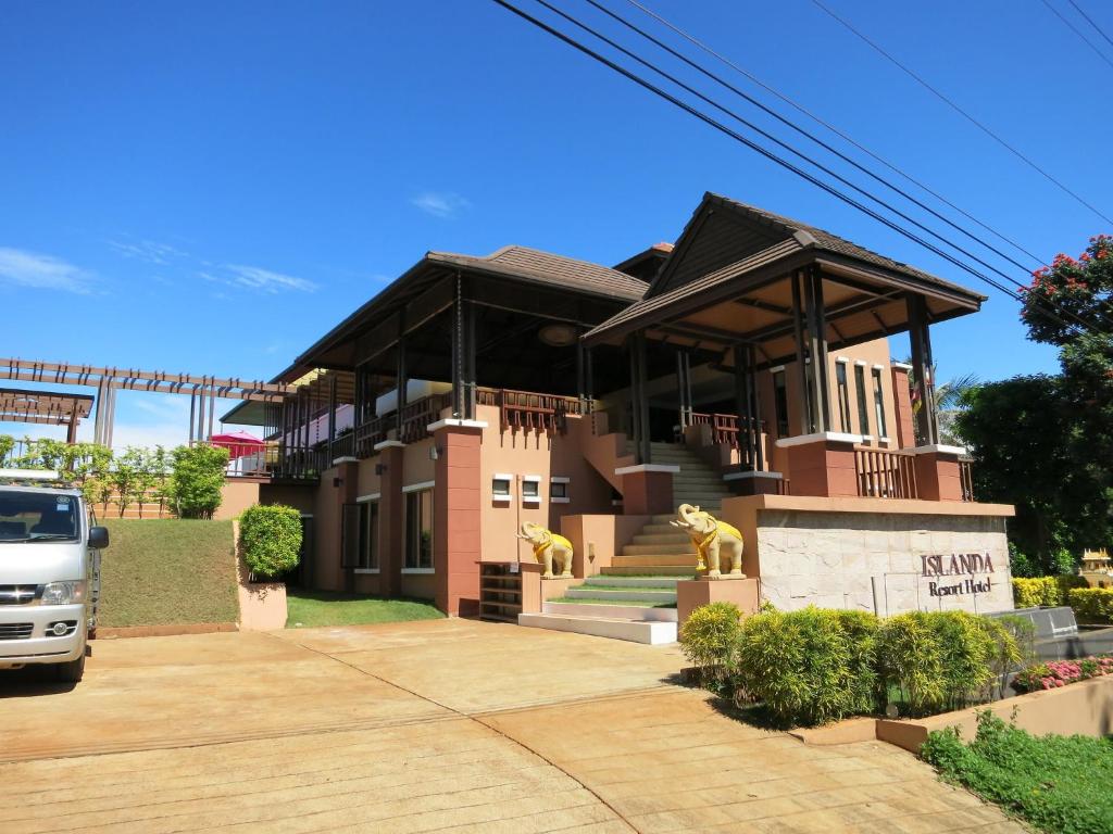 a house with two lion statues in front of it at Islanda Resort Hotel in Ko Mak