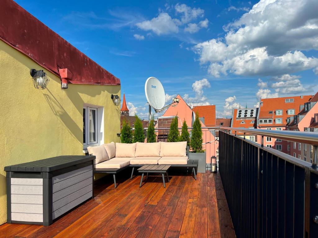 a balcony with a couch on a wooden deck at Nurban Apartments Oldtown in Nürnberg