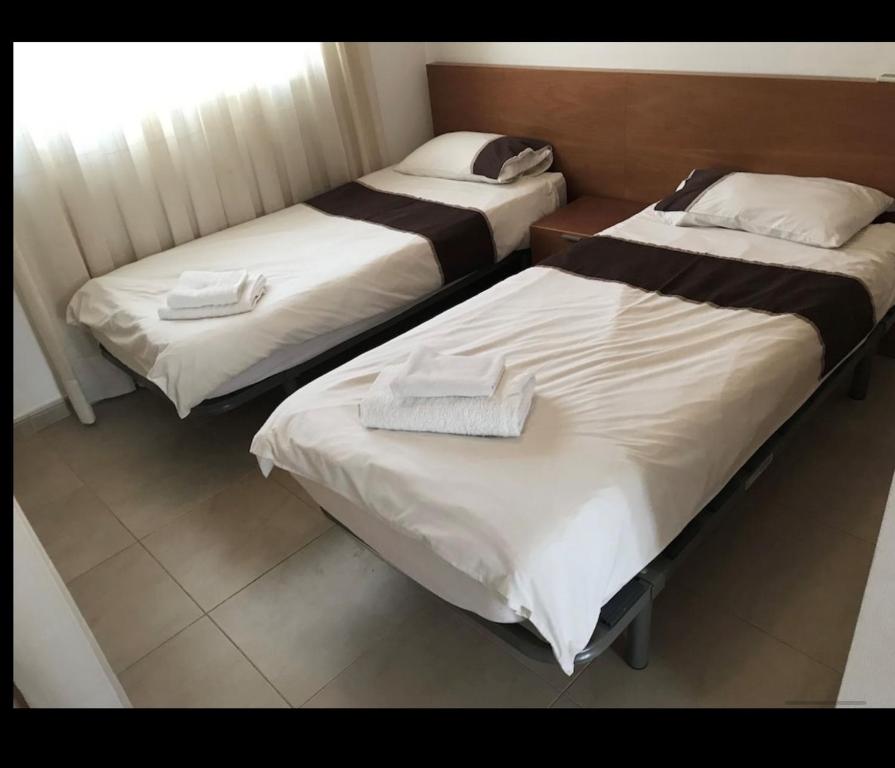 two beds in a hotel room with towels on them at PJA2-LT Bonita Villa localizado en La Torre Golf Resort in Torre-Pacheco