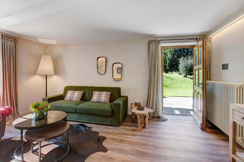 ein Wohnzimmer mit einem grünen Sofa und einem Tisch in der Unterkunft Chalet Sonne Superior2 4 in Livigno