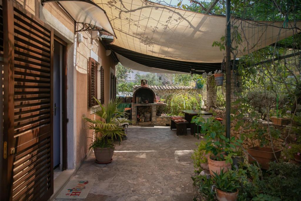 un patio extérieur avec une table, des chaises et des plantes dans l'établissement Apartman Silna your new home with terrace and garden, à Bobovišća