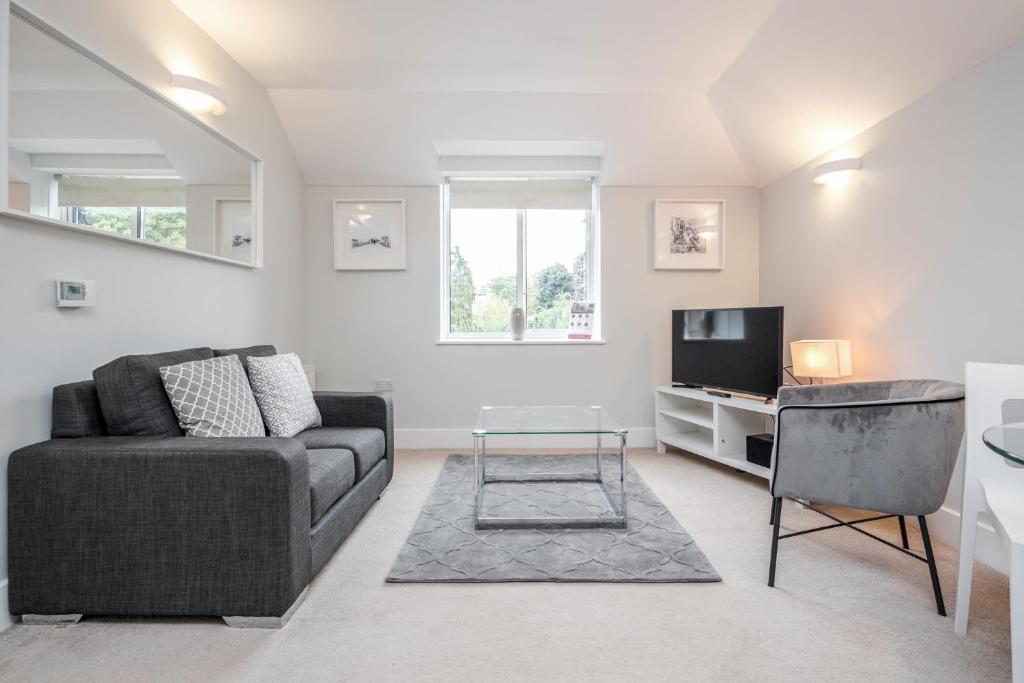 a living room with a couch and a tv at Roomspace Serviced Apartments - Lomond Court in Surbiton