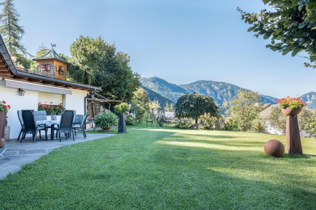 un jardín con mesa y sillas y montañas de fondo en Lotschenhof Apt Margerite en Trodena