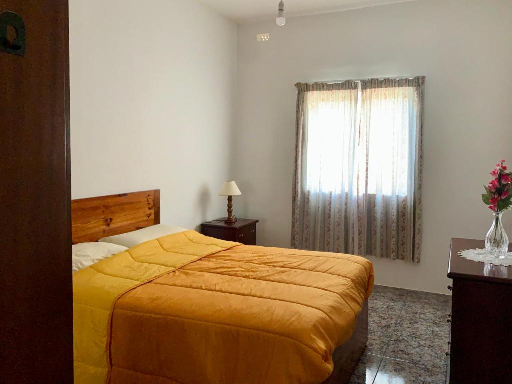 a bedroom with a yellow bed and a window at 2 Bedroom Appartment Birzebbugia in Birżebbuġa