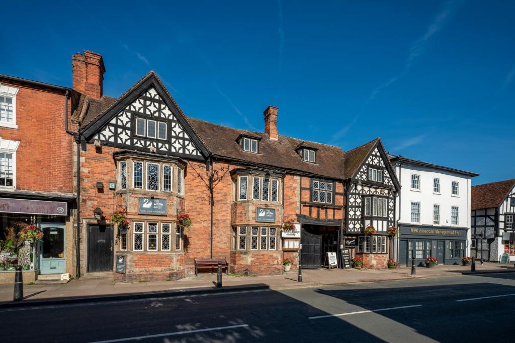 an old brick building on the corner of a street at The White Swan Hotel Bar & Restaurant in Henley in Arden