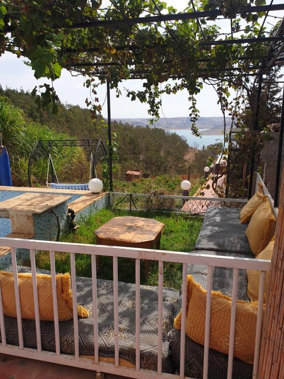 a room with a balcony with a table and benches at Ferme Bouhouch in Oulad Yakoub