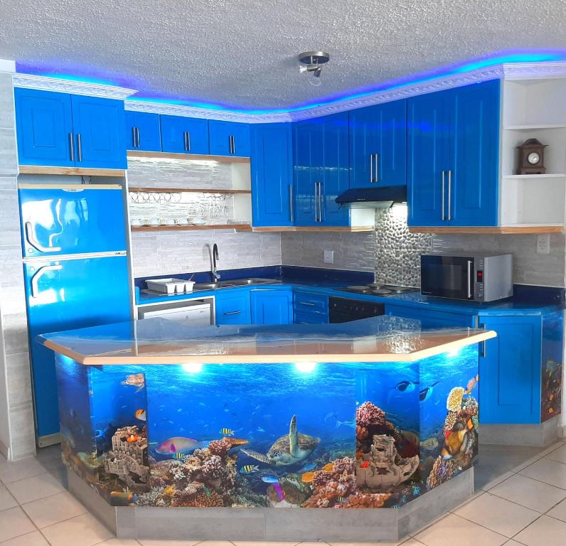 une cuisine avec des armoires bleues et un aquarium dans l'établissement Beach Splendor @ 24 La Crete Sands, à Margate