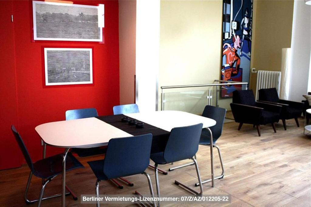 a table and chairs in a room with a red wall at City Apartment (barrierefrei) in Berlin