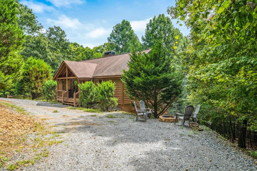 a cabin in the woods with two chairs at Wandering Bear's Den in Ellijay