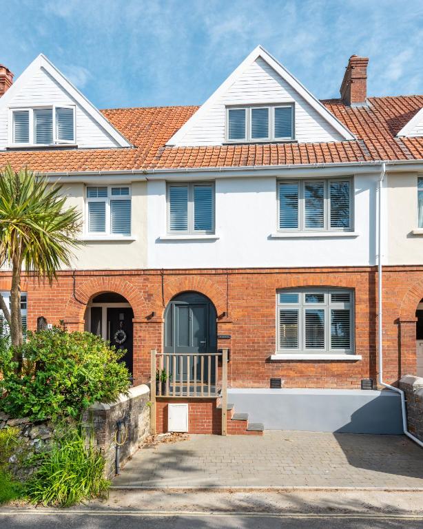 a brick house with a palm tree in front of it at Holly Hayes House in Instow