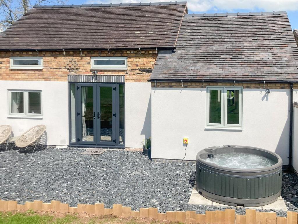 a house with a hot tub in front of it at Sheepfold Cottage in Eccleshall