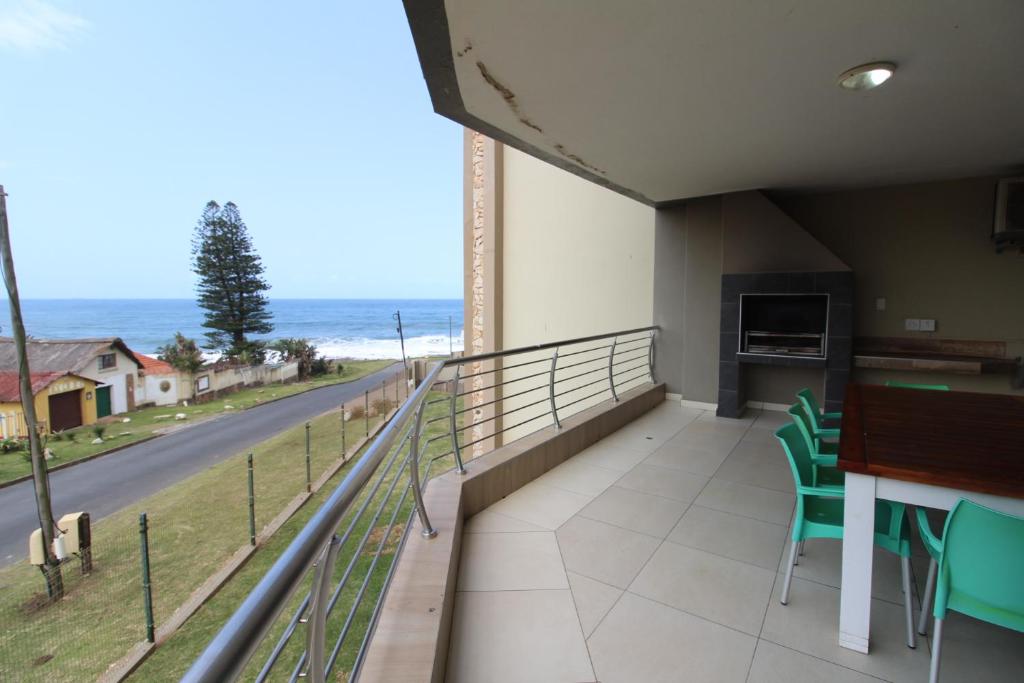 d'un balcon avec une table et des chaises et une vue sur l'océan. dans l'établissement Saints View Resort Unit 10, à Uvongo Beach