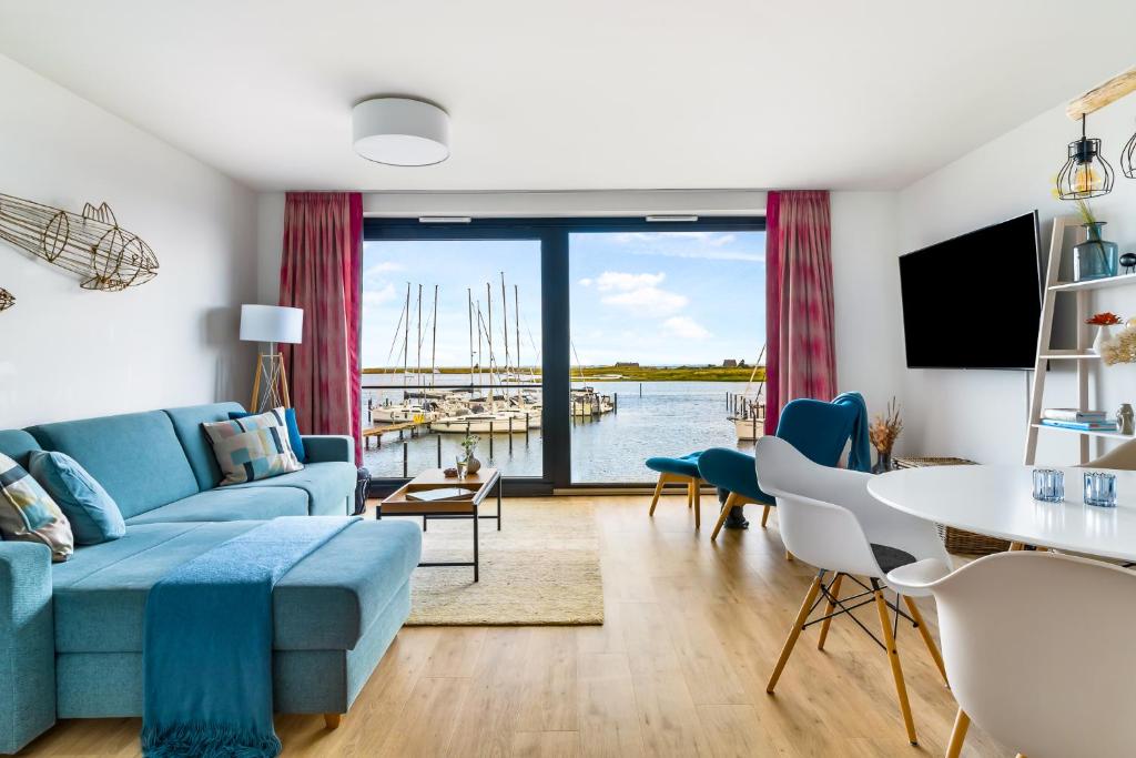 a living room with a blue couch and a table at Hafenquartier No5 in Heiligenhafen