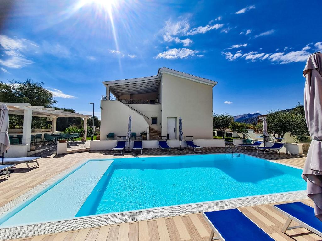 een villa met een zwembad en een huis bij Affittacamere Bellavista Posada in Posada