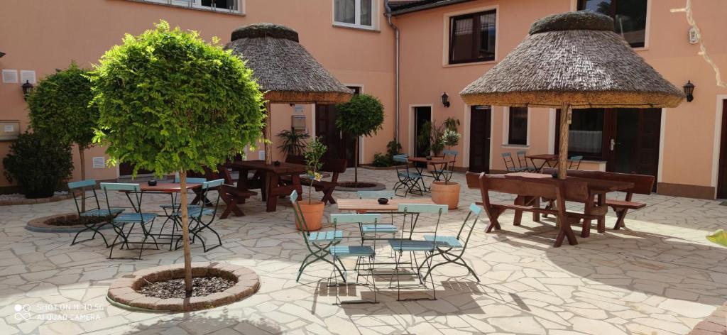a courtyard with tables and chairs and a tree at Pension Cubana in Rothenburg