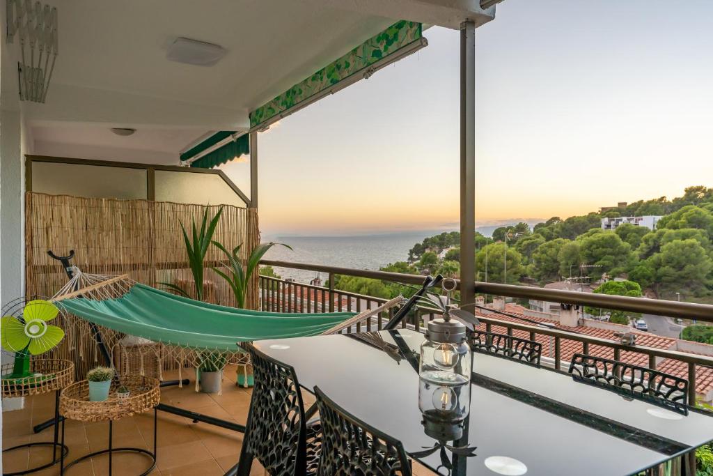 a balcony with a hammock and a view of the ocean at Beach Front Retro Hideaway in Salou in Salou