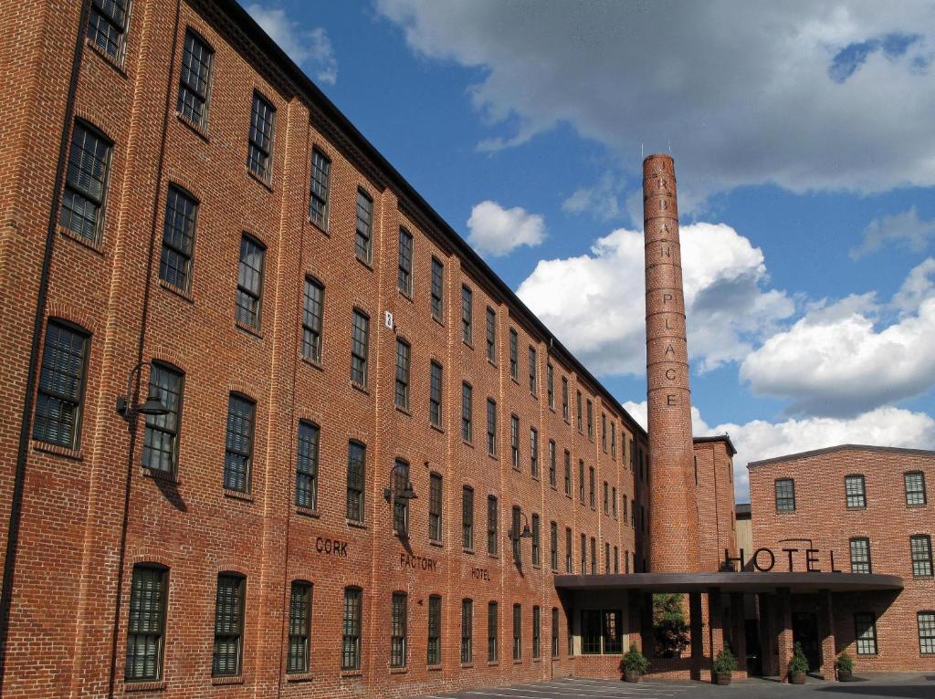 um grande edifício de tijolos com uma torre alta sobre ele em Cork Factory Hotel em Lancaster