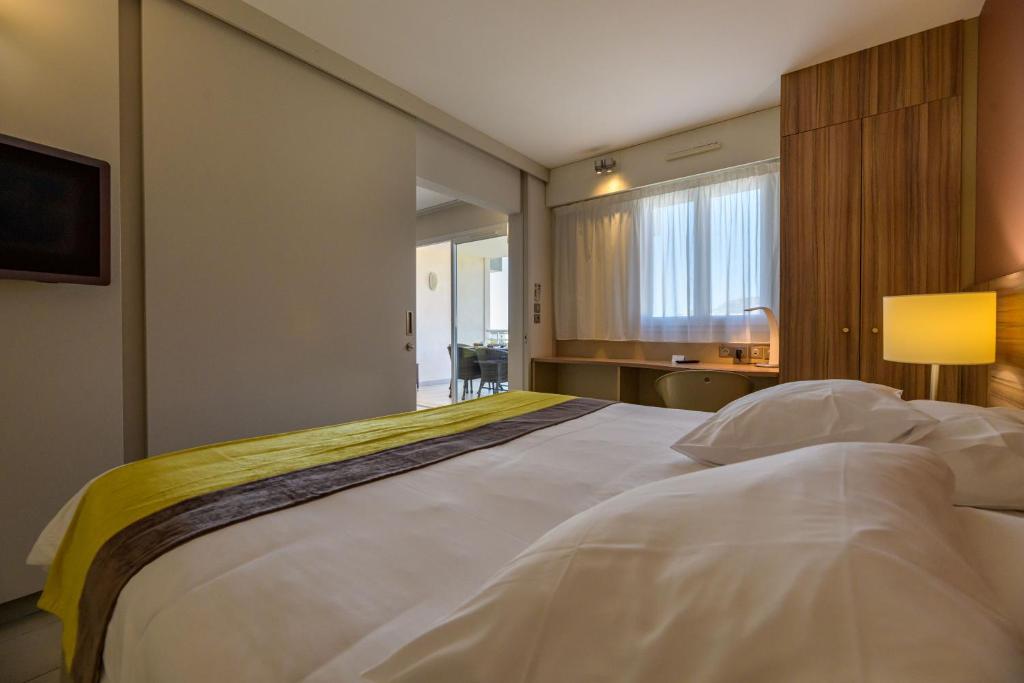 a large white bed in a room with a window at Residence de Tourisme Ajaccio Amirauté in Ajaccio