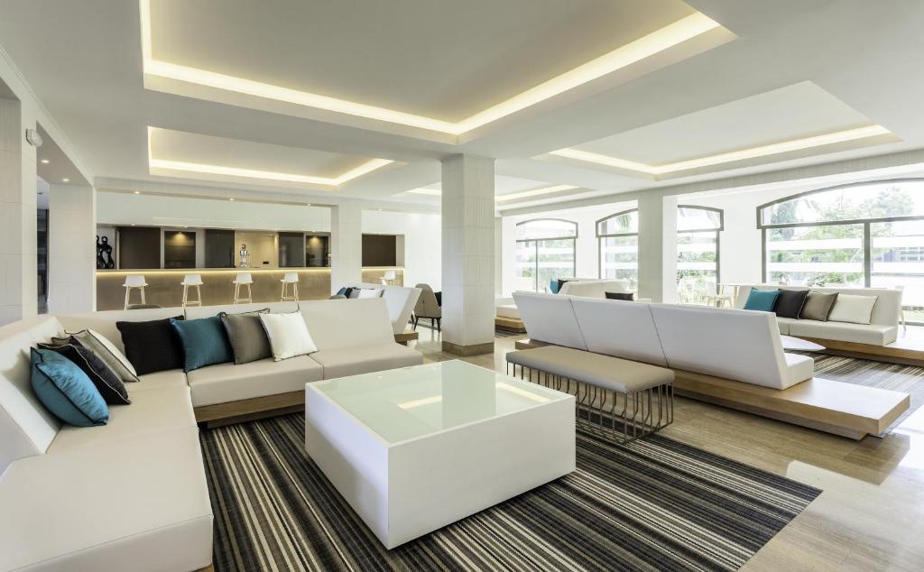 a living room with white couches and a coffee table at Ilunion Islantilla in Islantilla