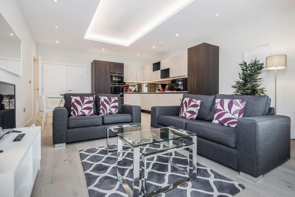 - un salon avec deux canapés et une table basse dans l'établissement Roomspace Serviced Apartments - Lockwood House, à Surbiton