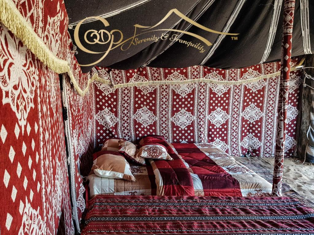 a woman laying on a bed in a room at Desert Private Camps - Private Bedouin Tent in Shāhiq