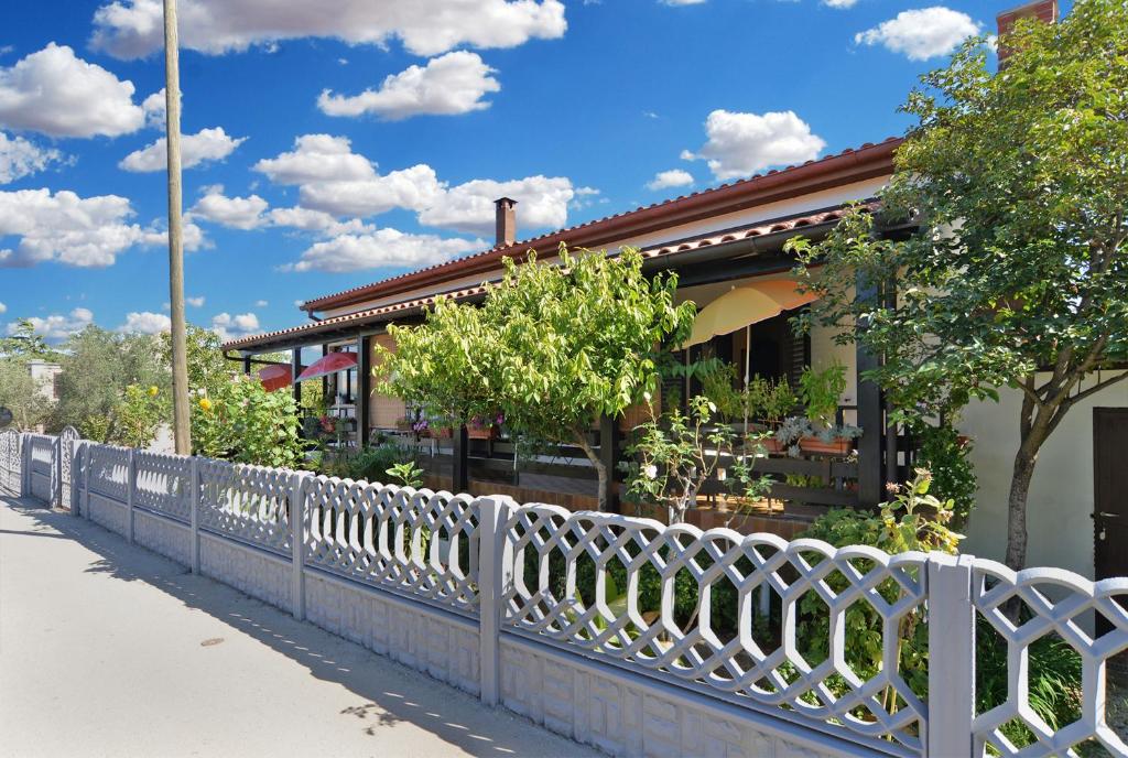 a white fence in front of a building at Rooms Veli Vrh 2208 in Pula