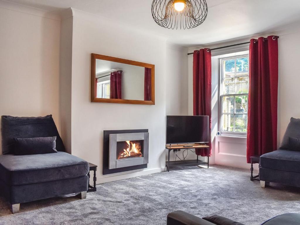 a living room with a fireplace and a tv at Bridge House in Holmfirth