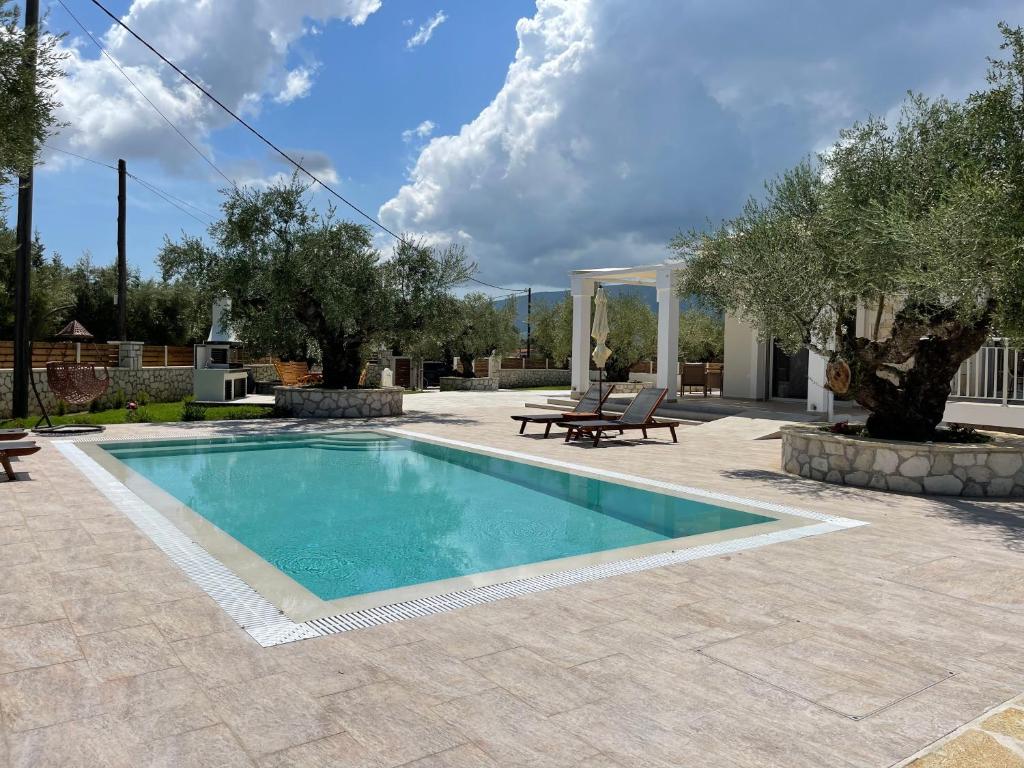 una piscina en un patio con mesa de picnic y bancos en Villa Niva, en Áyios Kírikos
