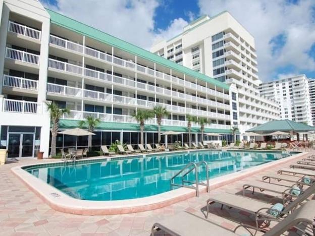 a swimming pool in front of a large building at Oceanfront Studio Condo With Balcony View Of Beach And Ocean In Daytona Beach Resort 1011 With 4 Pools Tiki Bar Grill in Daytona Beach