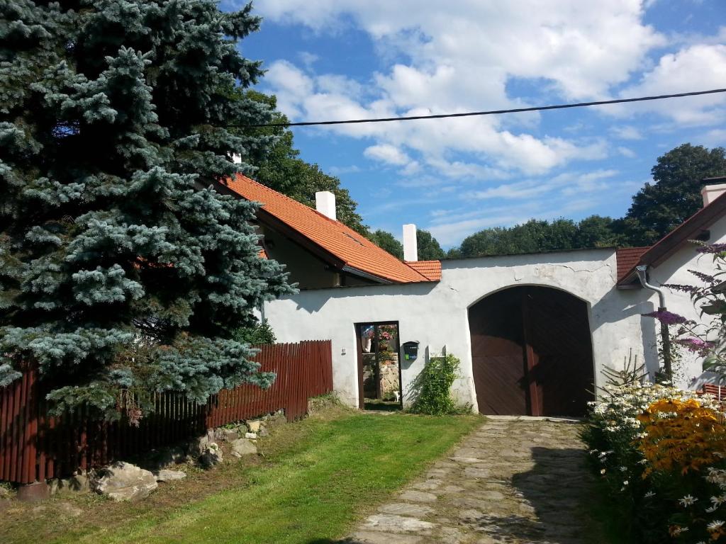 ein weißes Haus mit einem roten Zaun und einem Baum in der Unterkunft Apartmán Krátká in Krátká