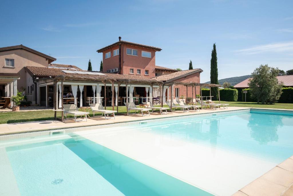 a large swimming pool in front of a house at Guadalupe Tuscany Resort in Braccagni