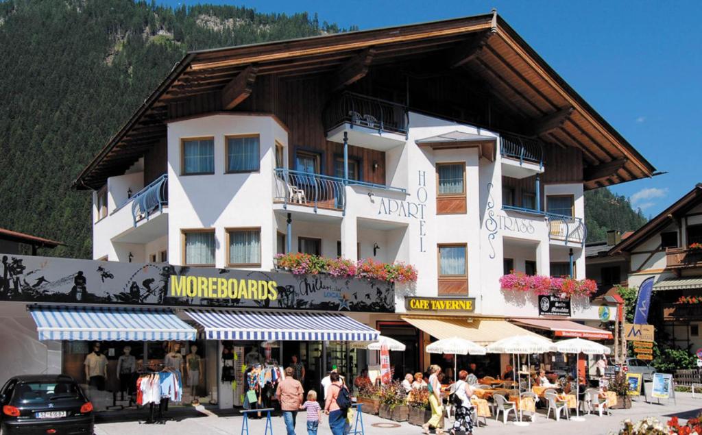 a large white building with people walking in front of it at Heart Hotel Nordstern in Mayrhofen