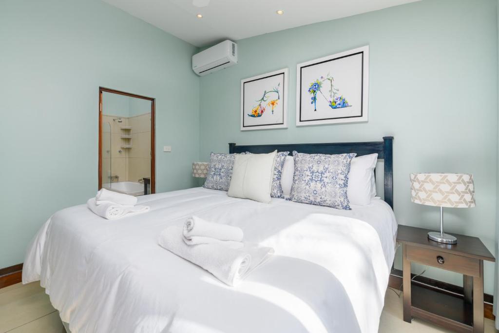 een slaapkamer met een groot wit bed en een spiegel bij San Lameer Villa 2806 - 3 Bedroom Classic - 6 pax - San Lameer Rental Agency in Southbroom