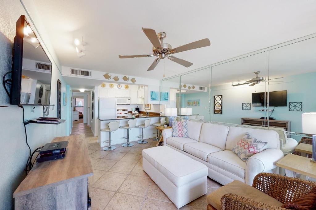 a living room with a white couch and a kitchen at Jetty East A516 in Destin
