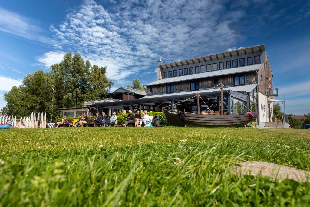 eine Gruppe von Personen, die außerhalb eines Gebäudes sitzen in der Unterkunft Pension Café Knatter in Ückeritz