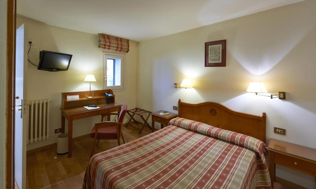 una habitación de hotel con una cama y un escritorio en Hotel Abat Cisneros Montserrat, en Montserrat