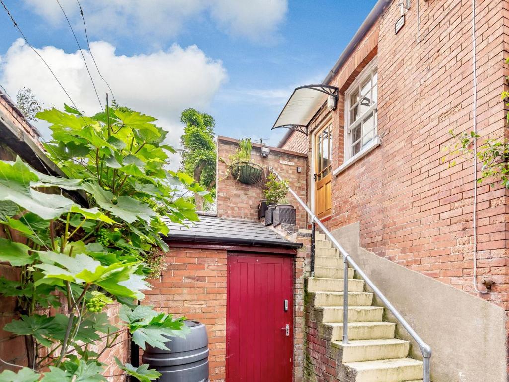 a brick house with a red door and stairs at Top Flat-uk35142 in Lincoln